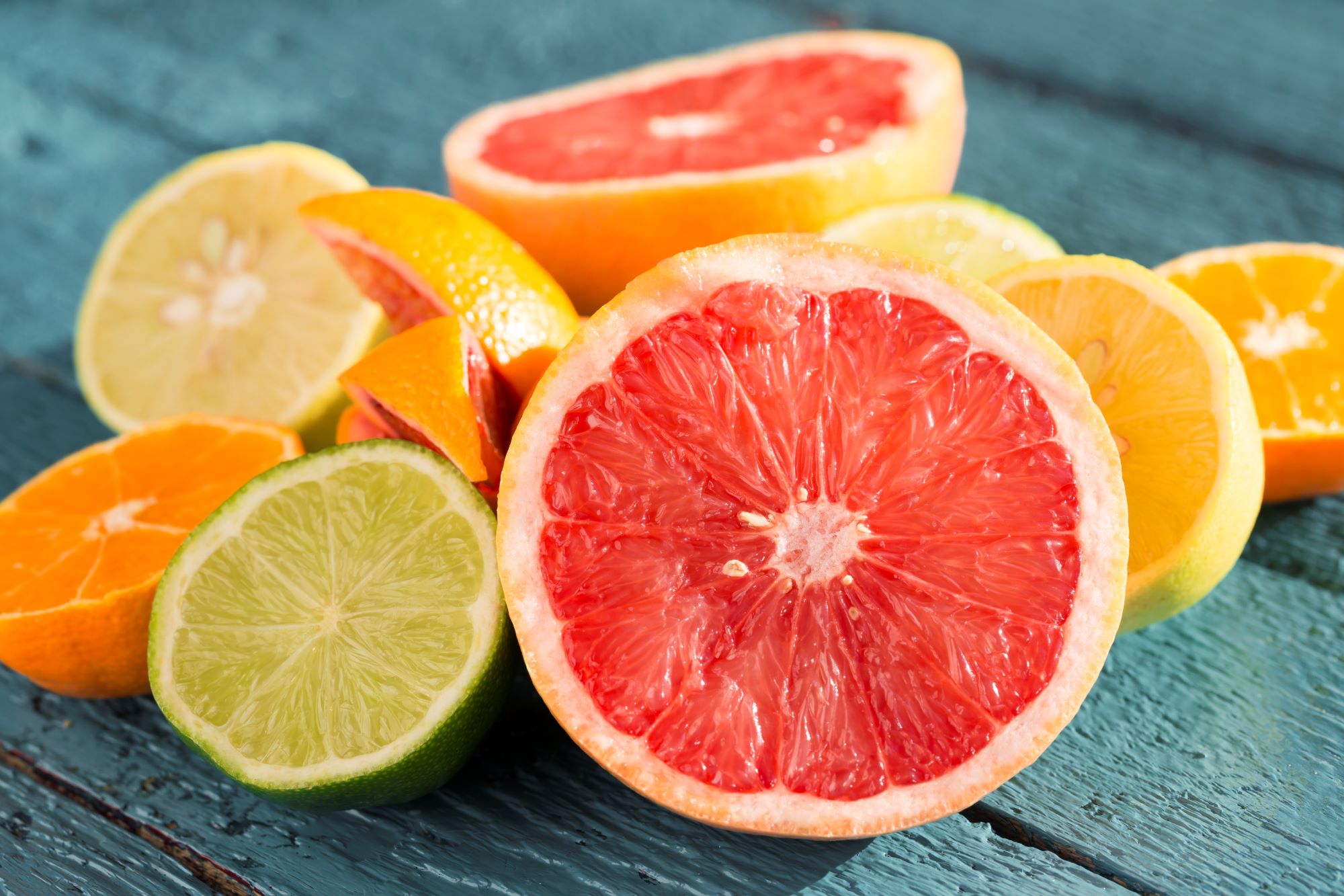 A delicious array of citrus fruits piled on a charcoal wood table