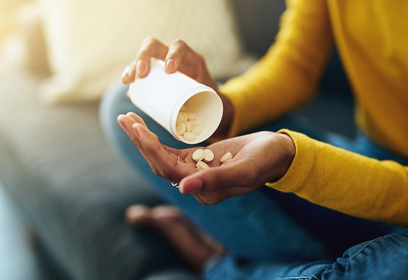 A woman pouring tablets into her hand