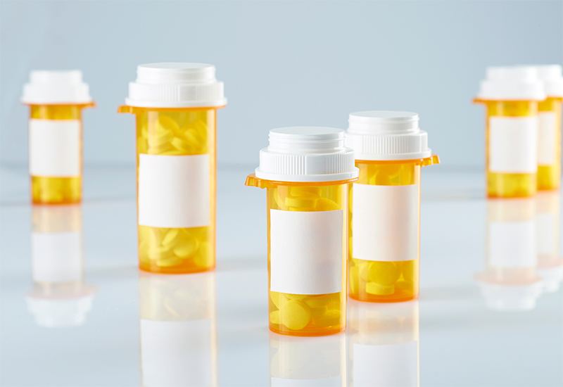 Pill bottles containing white medical tablets