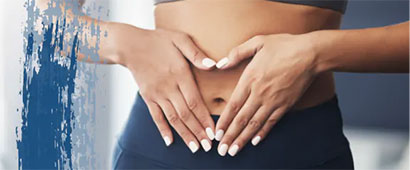A woman in workout clothes holding her flat stomach