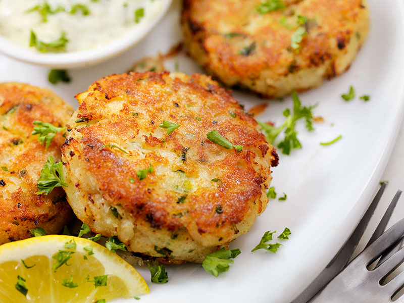 Tasty fish cakes sprinkled with herbs and served with lemon