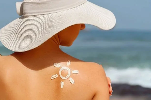 A woman in a hat enjoying the sun on the beach