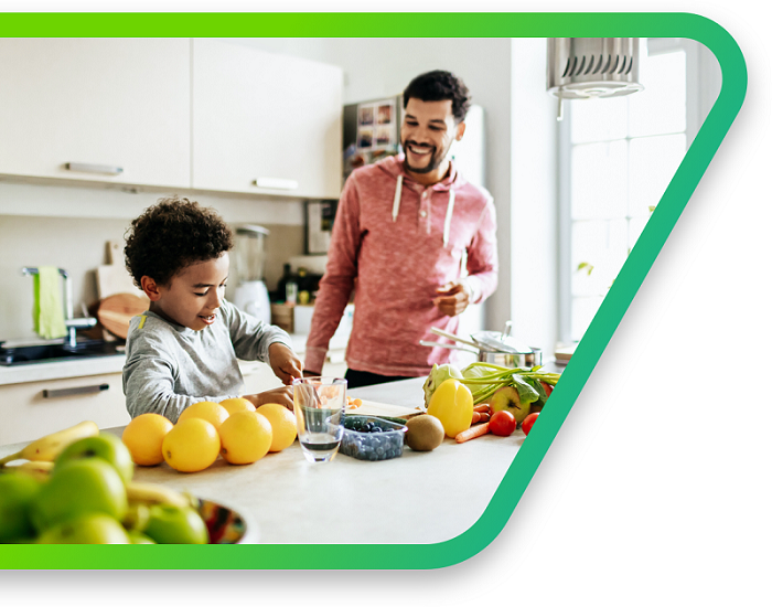 A father and son prep a healthy plant-based dinner with fresh fruits and vegitables