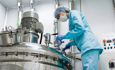 A worker checks on a chemical vat used for the blending of chemicals 